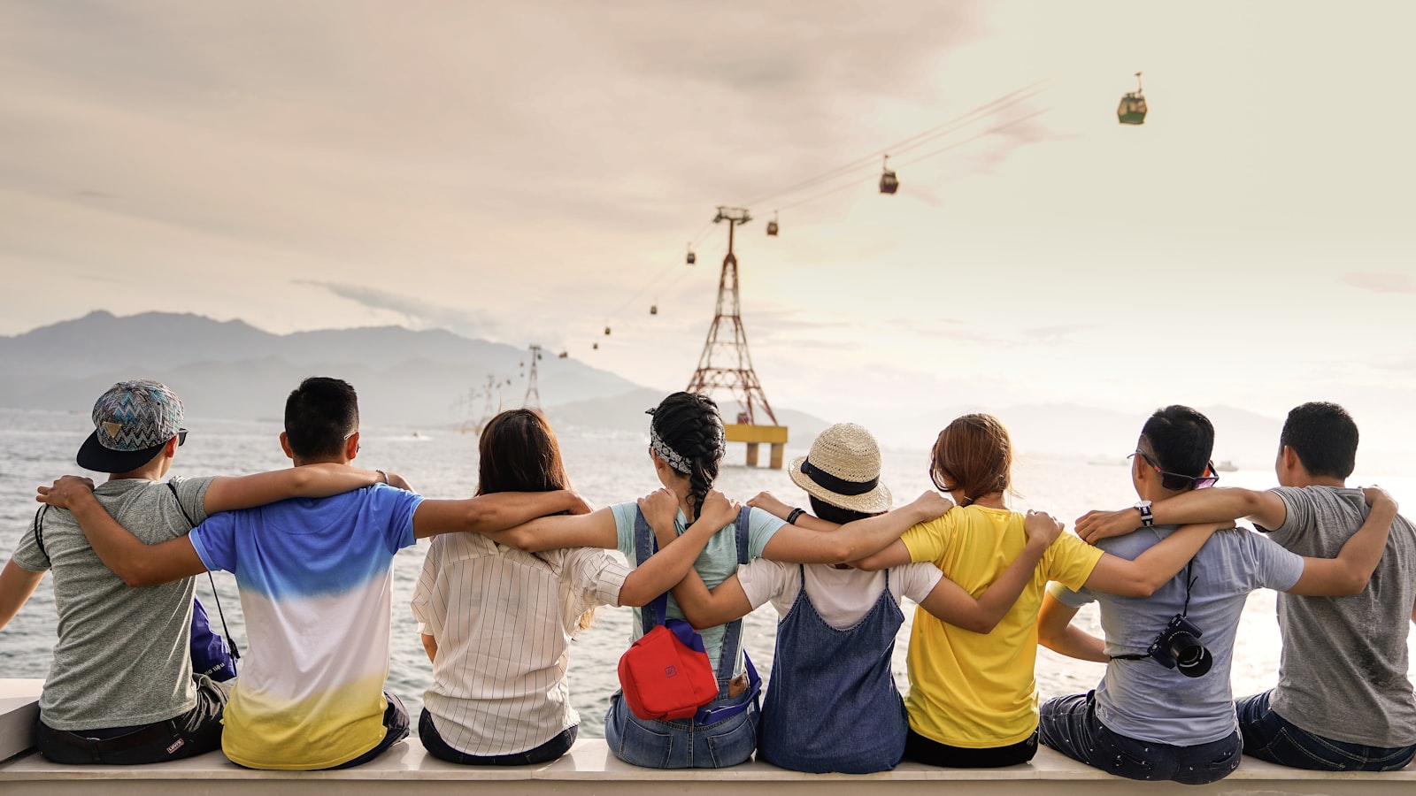 A group of friends sharing a candid, joyful moment outdoors in golden light